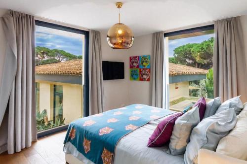 une chambre avec un lit et une grande fenêtre dans l'établissement Superb Villa in Ramatuelle, à Ramatuelle