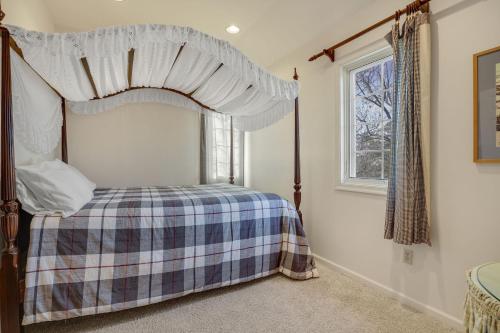 a bedroom with a canopy bed and a window at Wildflower - Waterfront & a deep water dock! in Black Point Landing