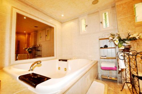 La salle de bains est pourvue d'une grande baignoire et d'un lavabo. dans l'établissement Sea View Apartment with Pool in Argelès, à Argelès-sur-Mer