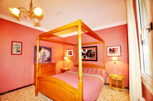 une chambre avec un lit à baldaquin et deux lampes dans l'établissement Sea View Apartment with Pool in Argelès, à Argelès-sur-Mer