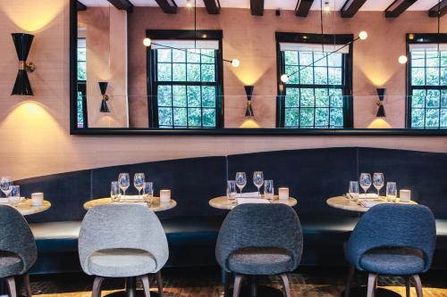 a row of tables in a restaurant with mirrors at The Dylan Amsterdam - The Leading Hotels of the World in Amsterdam
