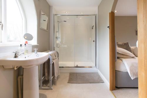 a bathroom with a sink and a shower at Grooms Cottage in Weedon Bec