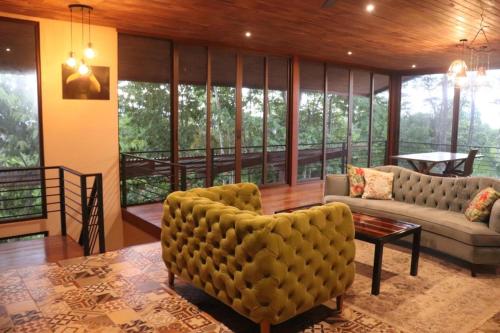 a living room with a couch and a chair at Eco Villas-Houses-Tents Corcovado-Mountain-Ocean Views in Puerto Jiménez