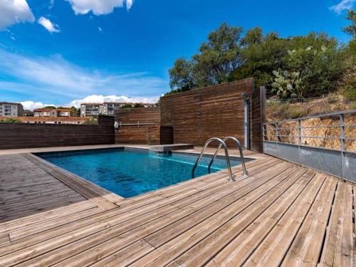 - une terrasse en bois avec une piscine au-dessus d'un bâtiment dans l'établissement Porto Vecchio Location estivale spacieux appartement 100 m2, à Porto-Vecchio
