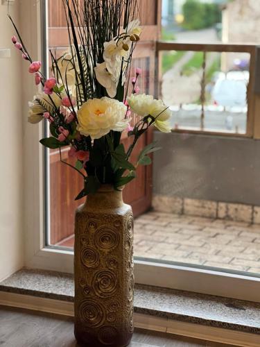 a vase filled with flowers sitting on a window sill at VipStay - Stilvoll und geräumige Apartments mit Terasse oder Balkon, Küche, kostenloses Parken, WLAN, Smart Tv in Wiesloch