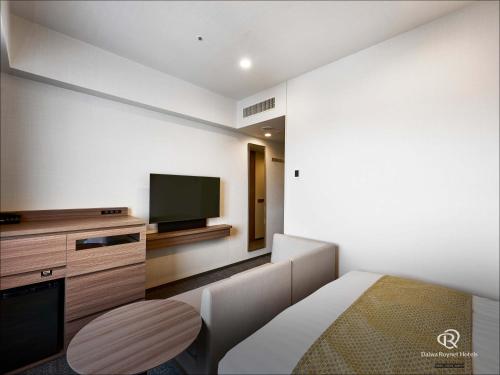 a small room with a bed and a television at Daiwa Roynet Hotel Akita Ekimae in Akita