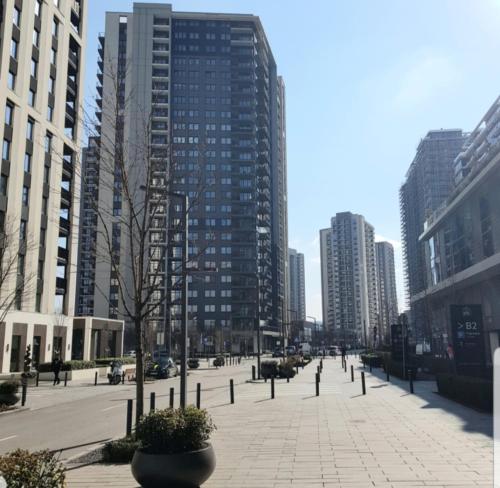 a city street with tall buildings in a city at Beograd na vodi - Belgrade Waterfront Iris Apartment in Belgrade