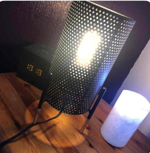 une lumière sur une chaise sur du parquet dans l'établissement chambre centre ville avec place de parking, à Fougères