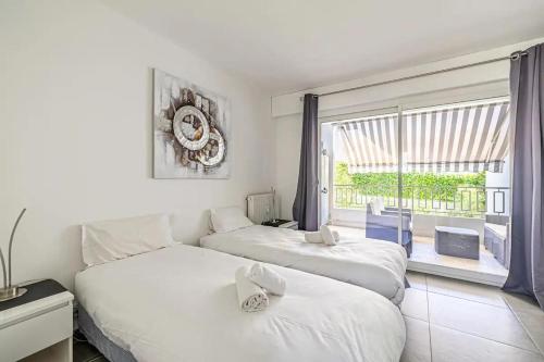 deux lits dans une chambre avec une grande fenêtre dans l'établissement SUPERBE 3P 2chambres, 2terrasses CANNES centre-ville, 4 min à pied de la Croisette sas-meredith loc, à Cannes