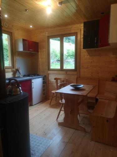 a kitchen with a wooden table in a cabin at Au petit bonheur in Le Tholy