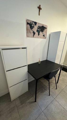 une table noire dans une pièce avec une croix sur le mur dans l'établissement Studio a Paris, à Paris