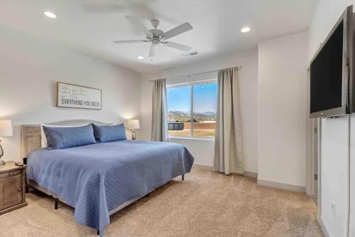 a bedroom with a blue bed and a window at Spacious 6-BR Retreat - Heated Pool Sleeps 16 in Santa Clara