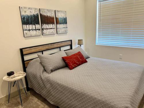 a bedroom with a bed with red pillows and a window at Spacious 6-BR Retreat - Heated Pool Sleeps 16 in Santa Clara