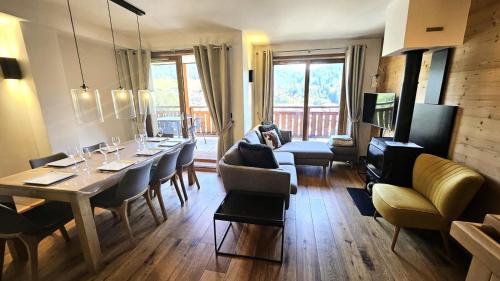 un salon avec une table et des chaises de salle à manger dans l'établissement Résidence Le Kilimandjaro - Proche centre - Vue sur le village et les montagnes MAE-0941, aux Gets