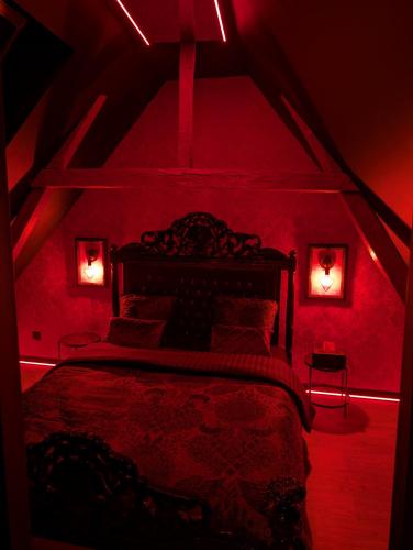 - une chambre avec un lit dans une chambre rouge dans l'établissement eroXens, à Saint-Amand-les-Eaux