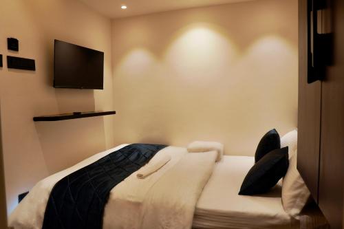 a bedroom with a bed with a television on the wall at Hotel Ichamati in Kolkata