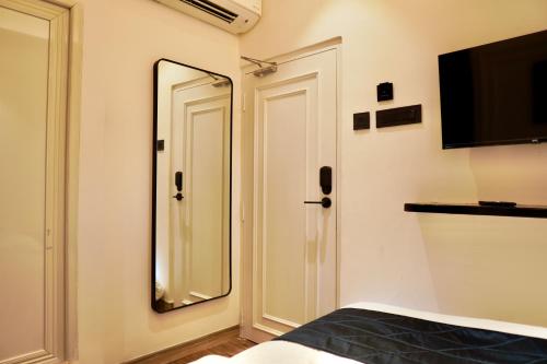 a bedroom with a mirror and a bed and a television at Hotel Ichamati in Kolkata