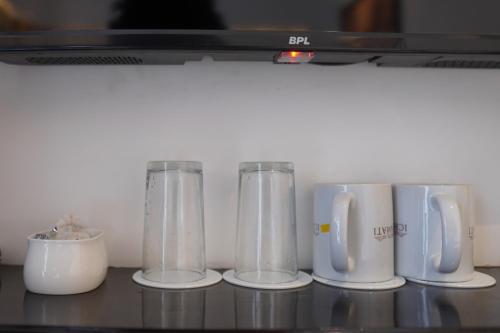 a row of glass blenders sitting on a counter at Hotel Ichamati in Kolkata