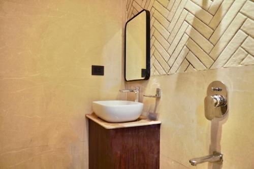 a bathroom with a white sink and a mirror at Hotel Ichamati in Kolkata
