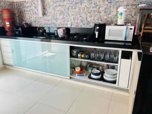 a kitchen counter with a glass cabinet with dishes at Pouso Canastra in São João Batista do Glória