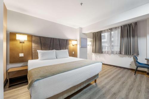 a hotel room with a bed and a chair at Hotel Montreal Metropolitan, BW Signature Collection in Montréal