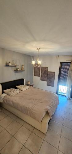 une chambre avec un grand lit et un lustre dans l'établissement T2 ajaccio ville, à Ajaccio