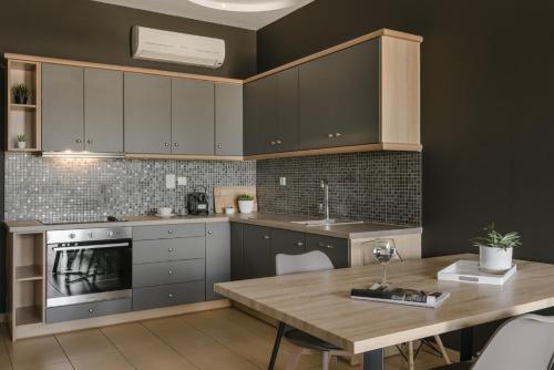 a kitchen with gray cabinets and a wooden table at Eviono Sea View Apt Afthonia - Anemelia in Lixouri