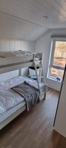 a bedroom with two bunk beds and a window at Lykkeli in Risør