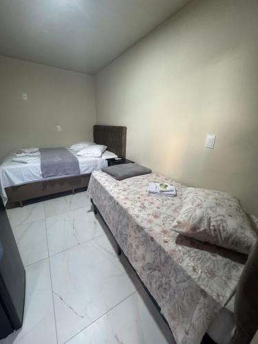two beds in a small room with at Residencial Lara 7 in Itapema