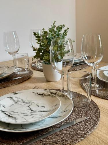 une table avec des assiettes et des verres à vin dessus dans l'établissement Le Secret D'Auron - Wifi - Hyper-Centre, à Bourges