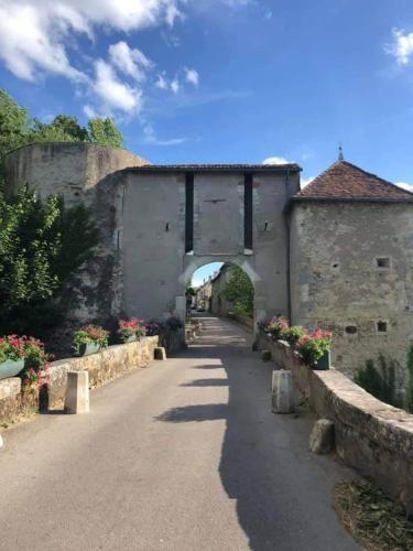 an old stone building with an arch over a road at La Maison Forestière in Liverdun