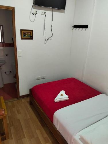 a room with a bed with a hat on it at Hotel Café Arábico in Líbano