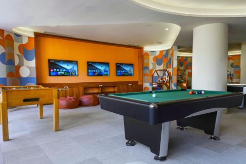 a billiard room with a pool table and two televisions at Grand Palladium Colonial Resort & Spa - All Inclusive in Akumal