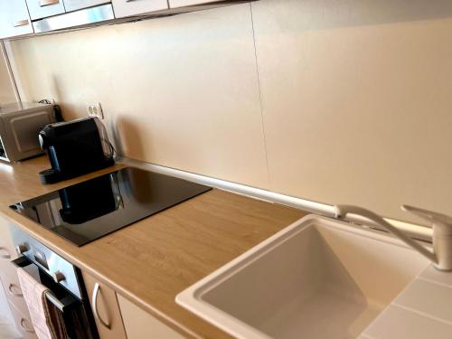 a kitchen counter with a sink and a microwave at Catedrala Blue in Constanţa