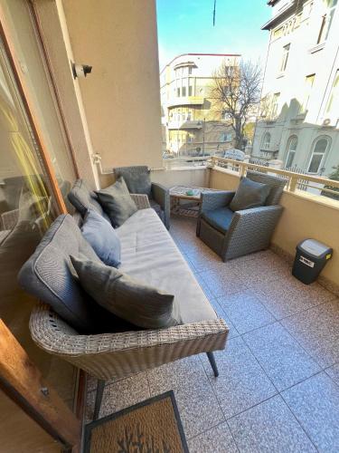a living room with a couch and chairs on a balcony at Catedrala Blue in Constanţa