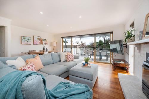 a living room with a couch and a tv at Family Beach Retreat With Heated Pool Blairgowrie in Blairgowrie
