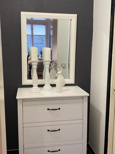 a white dresser with a mirror on top of it at Ferienhaus Luise, Mariannes Ferienwohnung in Rörvik