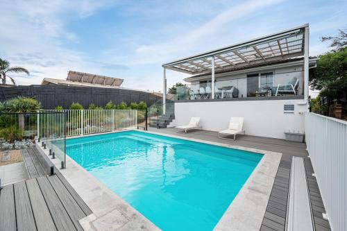 a swimming pool in the backyard of a house at Family Beach Retreat With Heated Pool Blairgowrie in Blairgowrie