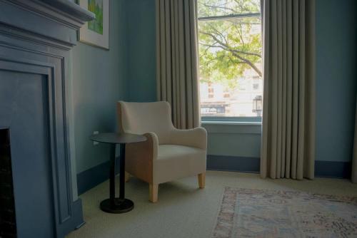 a chair and a table in a room with a window at The Woodward Hotel in Macon