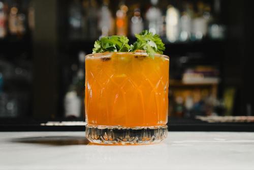 a orange drink with a garnishment on a table at The Woodward Hotel in Macon