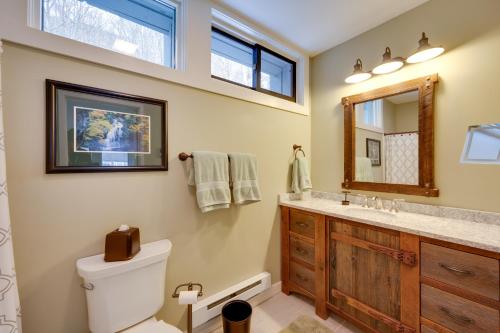 a bathroom with a toilet and a sink and a mirror at Lincoln Condo with Balcony and View Less Than 2 Mi to Loon Mtn in Lincoln