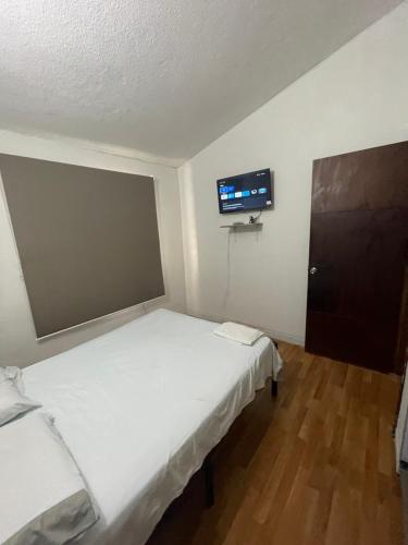 a room with two beds and a tv on the wall at Apartamento mejor zona residencial in Cúcuta