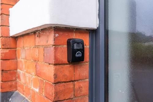 a socket on a brick wall next to a window at Bloom Court -Sleeps 6-Free Parking with Workspace & High-Speed WiFi in Birmingham
