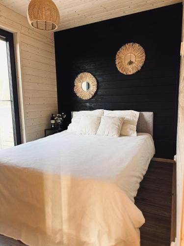 a bedroom with a large bed with two mirrors on the wall at Dom Kacprowy - Brzegi Lasu - dwa apartamenty na wyłączność z ogrodem in Lipnica
