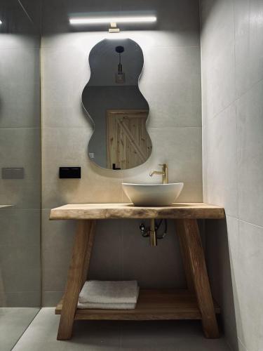 a bathroom with a sink and a mirror at Dom Kacprowy - Brzegi Lasu - dwa apartamenty na wyłączność z ogrodem in Lipnica