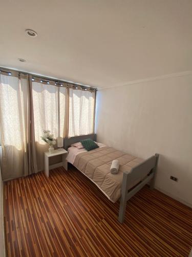 a bedroom with a bed in a room at Departamento Impecable in Santiago