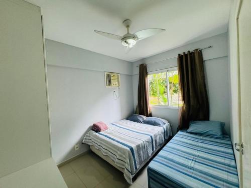 Un dormitorio con dos camas y una ventana en Apartamento Porto Real - Mangaratiba, en Mangaratiba
