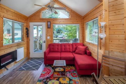a living room with a red couch and a fireplace at Sheltered Nook On Tillamook Bay in Bay City