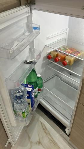 an open refrigerator filled with food and water bottles at Maison napolitaine in Naples