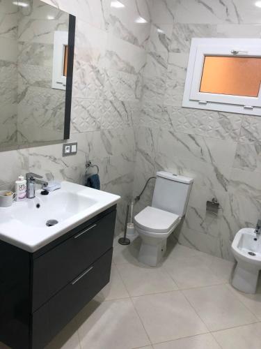 a bathroom with a toilet and a sink and a mirror at Appartement marina beach f5 n6 in M'diq